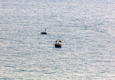 Two boats on the smooth surface of the sea.