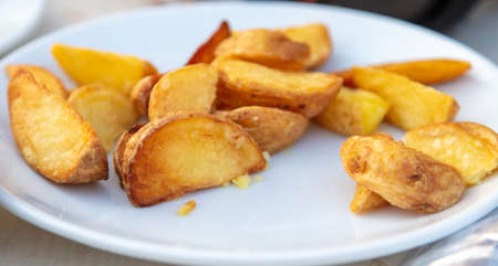 Fried potatoes in a plate on a table in a restaurant.の写真素材