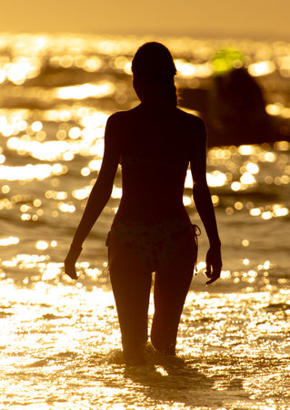 Girl in a swimsuit at the sea at sunset.の写真素材