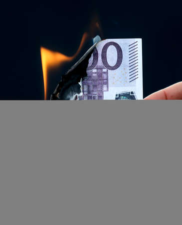 Five hundred Euros are burning with fire in hand isolated on black background.の写真素材