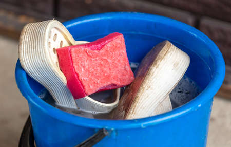 Blue bucket with dirty shoes. Close-upの写真素材