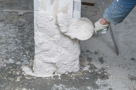 The man is plastering the walls in the house.