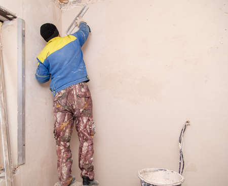 The man is plastering the walls in the house.の写真素材