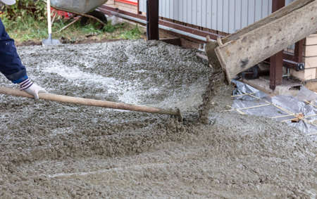 Workers level out the concrete mix at a construction site. Technologiesの写真素材