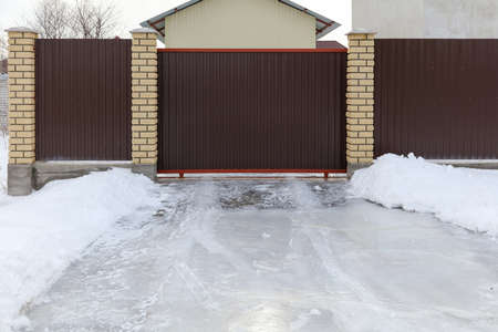 Snow at the gate with brick pillars.