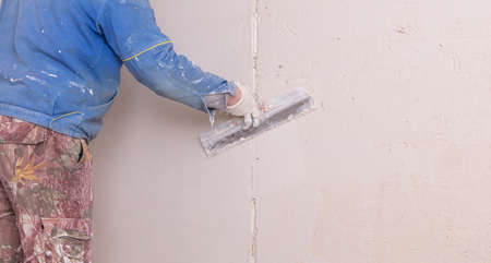 The man is plastering the walls in the house.の写真素材