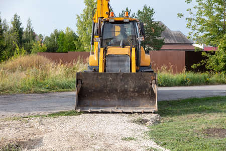 The tractor is working with rubble on the road. Constructionの写真素材