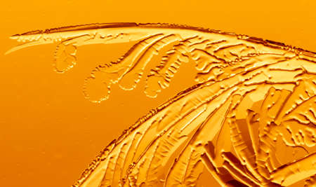 Gold patterns from frost on glass as a background. Close-up