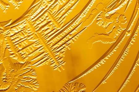 Gold patterns from frost on glass as a background. Close-up