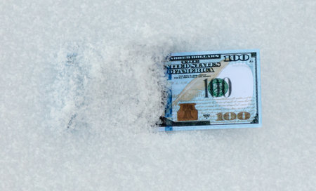 One Hundred Dollars lie in the snow. Close-upの写真素材
