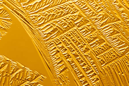 Gold patterns from frost on glass as a background. Close-upの写真素材