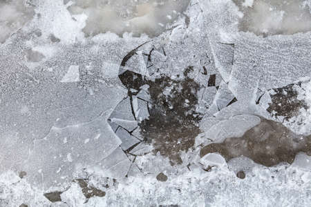 Crushed ice in a puddle as an abstract background. Winter