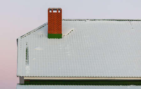 Snow on the roof of the house in winter.