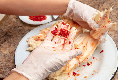 A woman is salting cabbage in Korean in the kitchen. Process