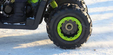 The ATV rides in the snow in winter.