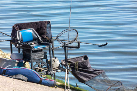 Chair with fishing rods by the pond.の写真素材