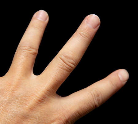 Fingers on a man's hand isolated on a black background.の写真素材