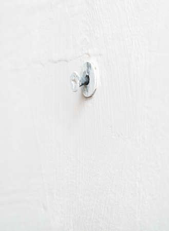 Self-tapping screw in a white wall. Close-up