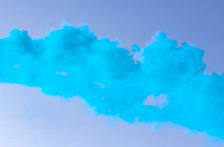 Blue smoke on a blue sky background.の写真素材