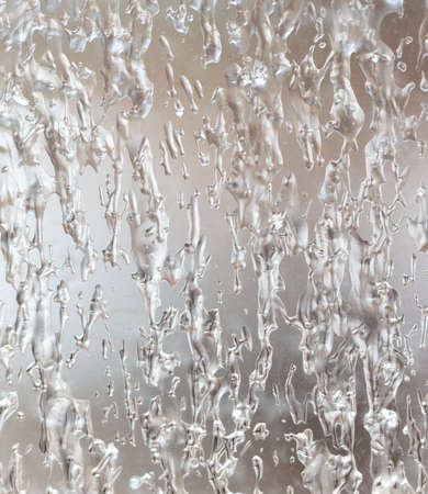 Frozen drops of water on a glass window as an abstract background. Texture