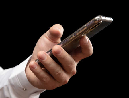 Phone in hand isolated on black background.の写真素材