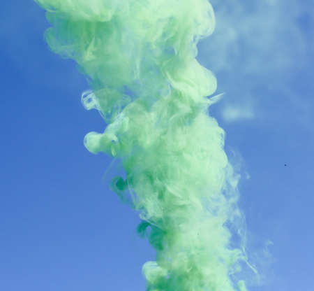 Green smoke on a blue sky background.の写真素材