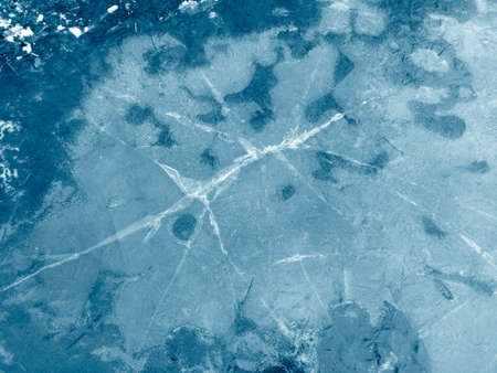Cracked ice in a puddle. Nature in winter.
