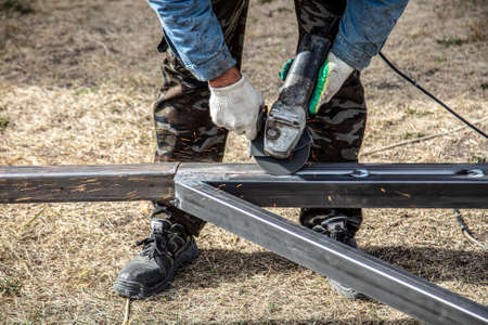 A worker cuts metal at a construction site.の写真素材