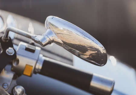 A steering wheel with a mirror on the bike.