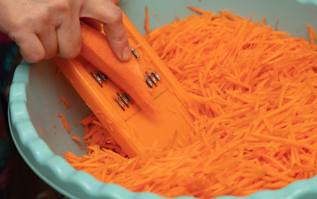 Woman chop carrots on a grater. Processの写真素材