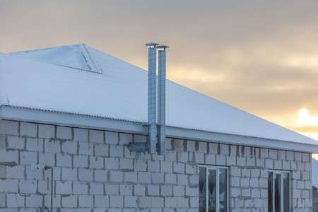 Chimney on the roof of a house with snow. Nature in winterの写真素材