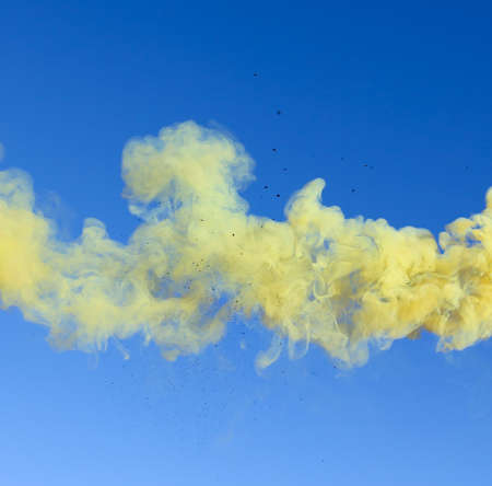 Yellow smoke on a blue sky background.
