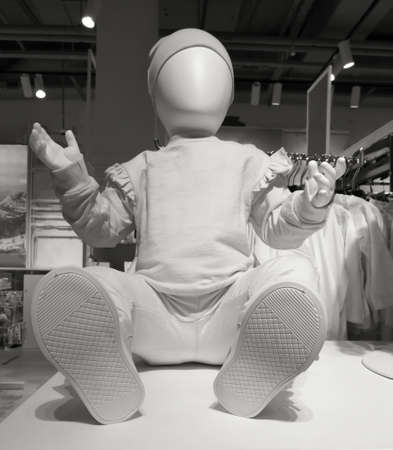 A child's dummy in clothes on a showcase in a market. black and white photoの写真素材