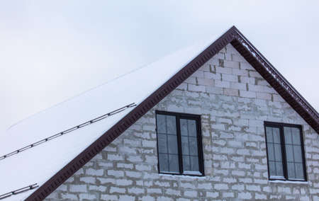 Snow on the roof of the house. Nature in winterの写真素材