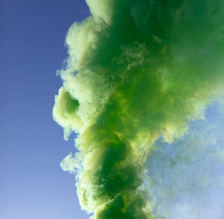 Green smoke on a blue sky background.の写真素材