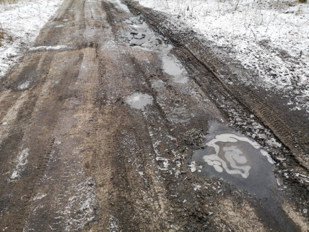 Frozen puddles on a dirt road. Nature in winterの写真素材