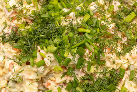 Olivier salad sprinkled with dill and herbs as a background. close-upの写真素材