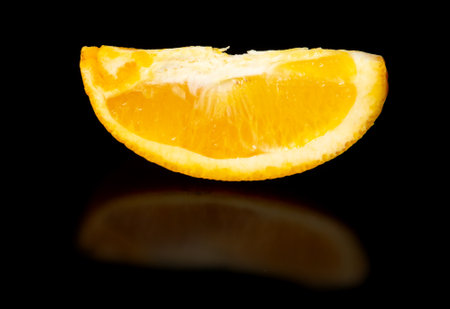 A slice of orange on a black background. close-upの写真素材