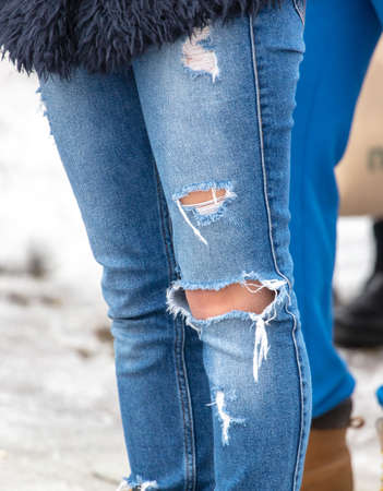 Ripped jeans on girl's legs.