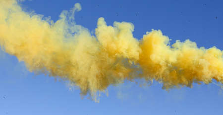 Yellow smoke on a blue sky background.