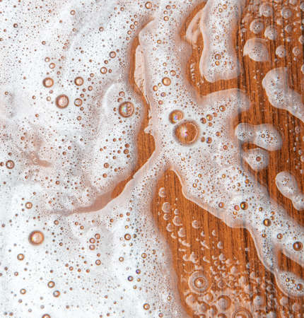 Soap foam on a wooden background. abstraction