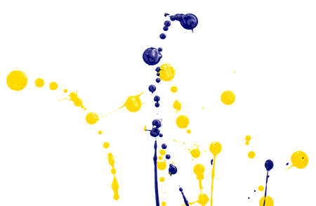 Drops of yellow and blue paint on a white paper background. Close-upの写真素材