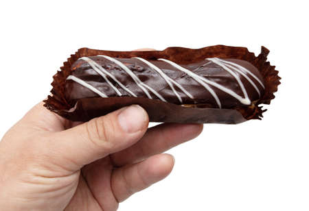 Eclair in hand isolated on white background. food