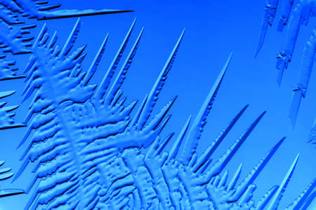 Gold patterns from frost on glass as a background. Close-up