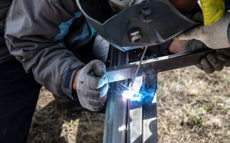A worker welds metal at a construction site.