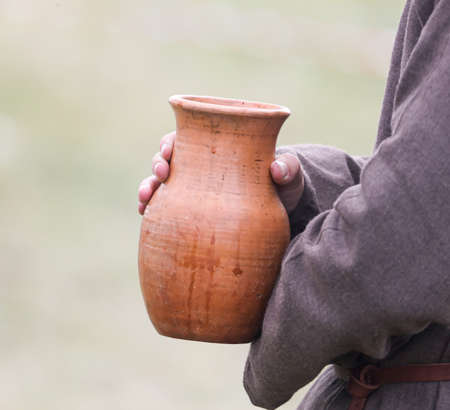Earthen vessel in human hands.の写真素材