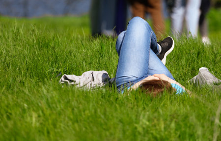 Girl lies on the grass in the parkの写真素材