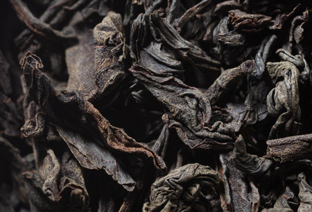 Dried black tea leaves as background. close-up
