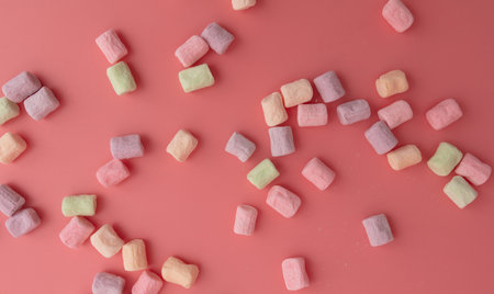 Multicolored candies on a pink background.の写真素材