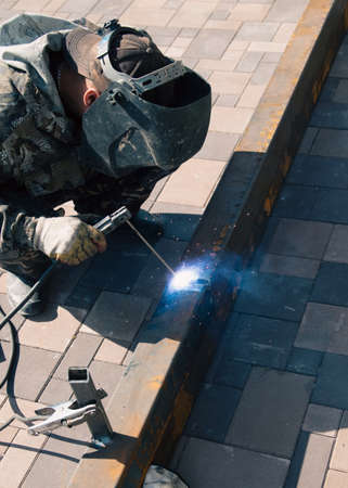 A worker works with metal welding at a construction site. Technologyの写真素材